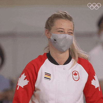 A Woman Wearing A Face Mask And A Jacket With A Canadian Maple Leaf On The Sleeves GIF