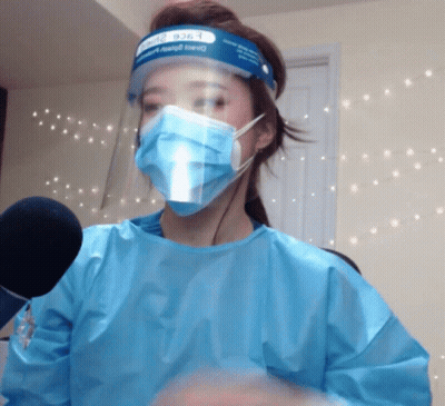 A Woman Wearing A Face Shield And Surgical Mask GIF