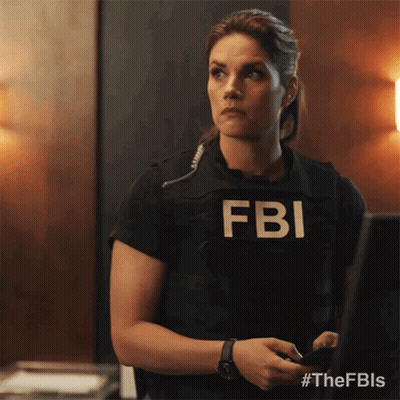 A Woman Wearing A Fbi Vest Is Standing In Front Of A Computer GIF