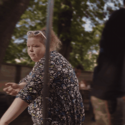 A Woman Wearing A Floral Dress And White Sunglasses GIF