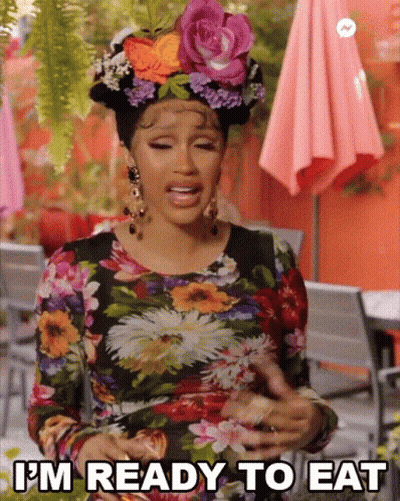 A Woman Wearing A Floral Dress Is Ready To Eat GIF