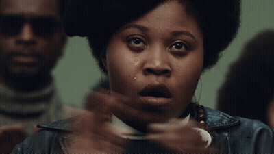 A Woman Wearing A Free Fred Hampton Badge GIF