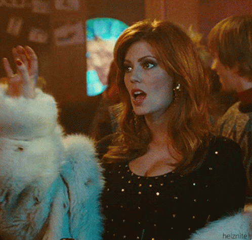 A Woman Wearing A Fur Coat And A Black Top With Gold Dots GIF