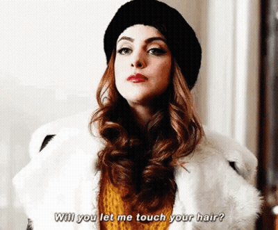 A Woman Wearing A Fur Coat And A Hat Is Talking To Another Woman . GIF