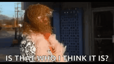 A Woman Wearing A Fur Coat Is Standing In Front Of A Building And Asking Is That Who I Think It Is ? GIF