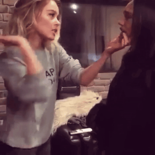 A Woman Wearing A Gap Sweatshirt Talks To A Man GIF