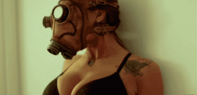 A Woman Wearing A Gas Mask With A Tattoo On Her Arm . GIF
