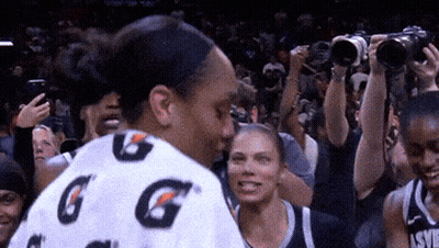 A Woman Wearing A Gatorade Shirt Stands In A Crowd GIF