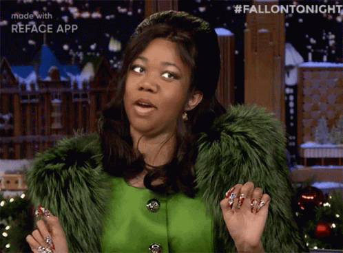 A Woman Wearing A Green Fur Coat And Red Nails Is Making A Face GIF