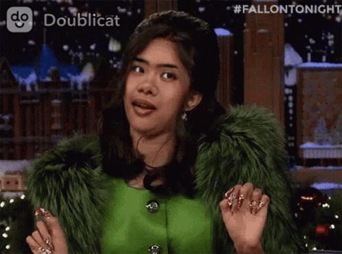 A Woman Wearing A Green Fur Coat Is Making A Funny Face GIF