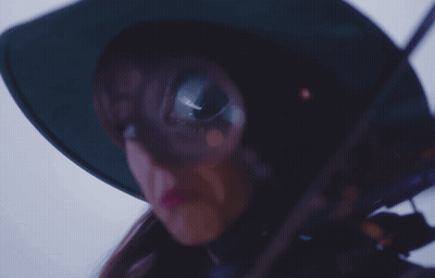 A Woman Wearing A Green Hat And Holding A Violin GIF