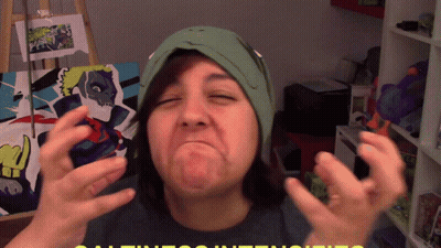 A Woman Wearing A Green Hat Is Making A Funny Face In Front Of A Painting GIF