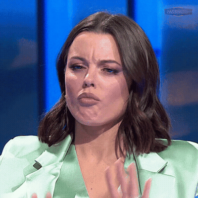 A Woman Wearing A Green Jacket Is Making A Funny Face GIF