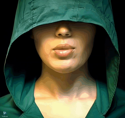 A Woman Wearing A Green Jacket With A Hood And The Word Valdez On The Bottom Right GIF