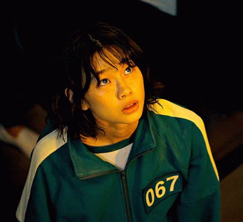A Woman Wearing A Green Jacket With The Number 067 On The Sleeve GIF
