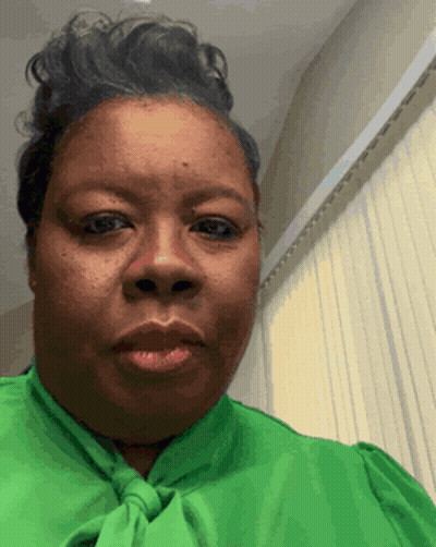 A Woman Wearing A Green Shirt And Tie Is Making A Funny Face GIF