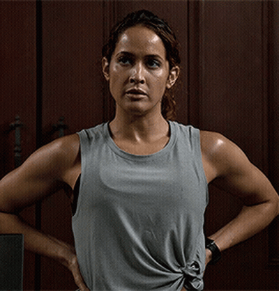 A Woman Wearing A Grey Tank Top With Her Hands On Her Hips GIF