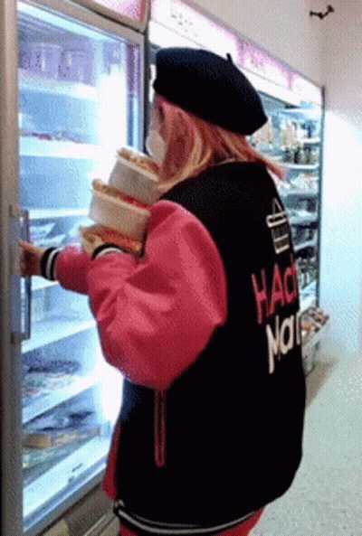 A Woman Wearing A Hack Nation Jacket Holds A Stack Of Food GIF