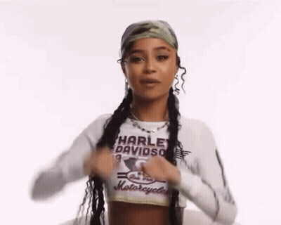 A Woman Wearing A Harley Davidson Shirt Is Holding Her Hair In Pigtails . GIF