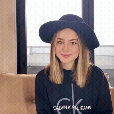 A Woman Wearing A Hat And A Calvin Klein Jeans Shirt GIF