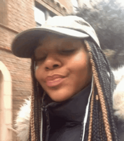 A Woman Wearing A Hat And A Jacket Is Making A Face . GIF