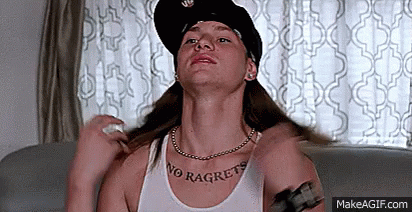 A Woman Wearing A Hat And A Necklace Is Sitting On A Couch And Looking Up . GIF