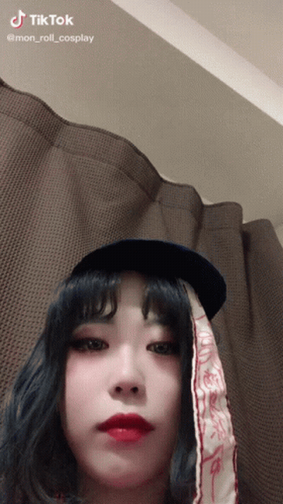 A Woman Wearing A Hat And A Scarf With Tiktok Written On The Bottom GIF