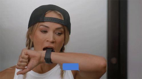 A Woman Wearing A Hat And A Smart Watch Looks At Her Watch With A Message On It GIF