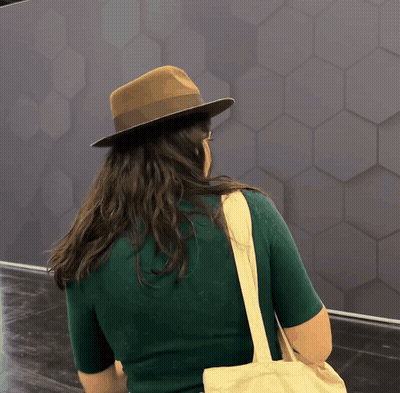 A Woman Wearing A Hat And Carrying A Bag GIF