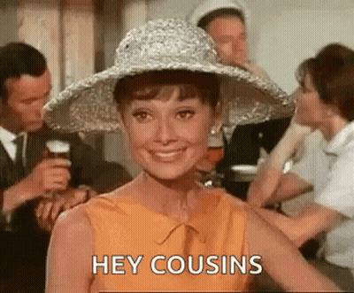 A Woman Wearing A Hat Is Smiling And Saying `` Hey Cousins '' While Standing In Front Of A Group Of People . GIF