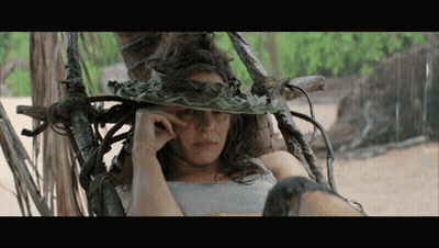 A Woman Wearing A Hat Made Of Leaves And Vines GIF