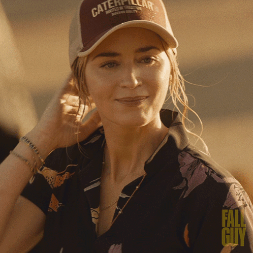 A Woman Wearing A Hat That Says Caterpillar GIF