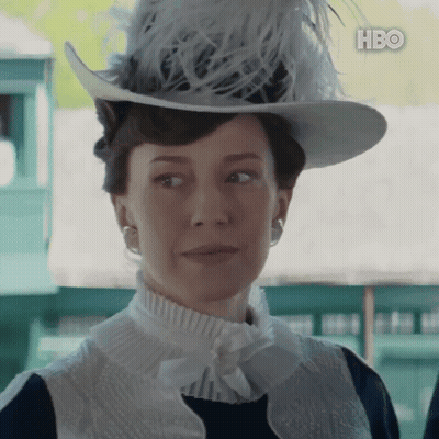 A Woman Wearing A Hat With Feathers And A Hbo Logo GIF