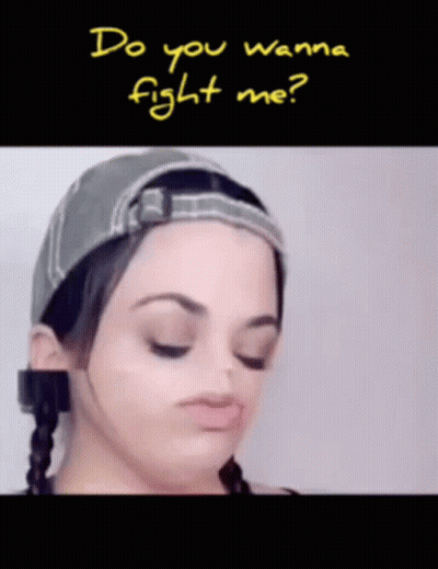 A Woman Wearing A Hat With The Words Do You Wanna Fight Me Written Above Her GIF