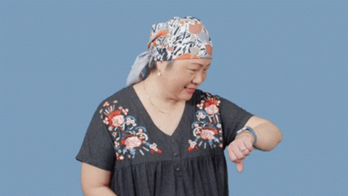 A Woman Wearing A Head Scarf Salutes In Front Of A Blue Background That Says Just In Time GIF