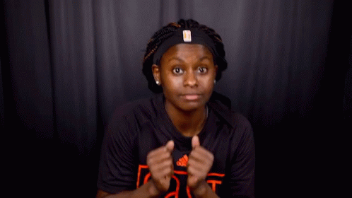 A Woman Wearing A Headband And A Black Shirt That Says As GIF