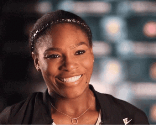 A Woman Wearing A Headband And A Necklace With The Letter E On It GIF