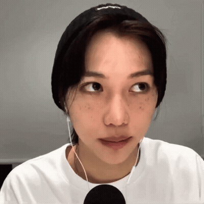 A Woman Wearing A Headband And Earbuds Looks To The Side GIF