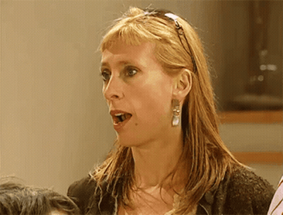A Woman Wearing A Headband And Earrings Looks Surprised And Shocked GIF