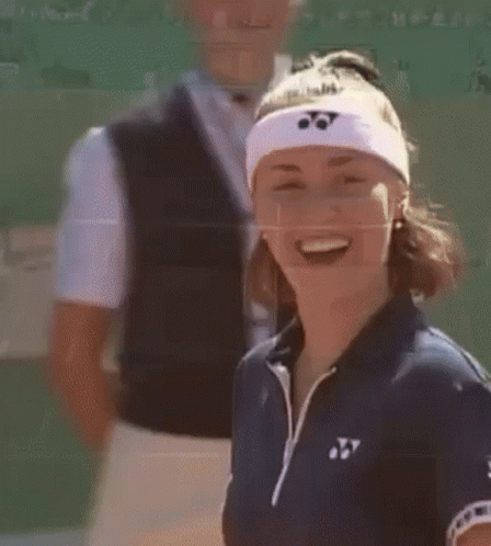 A Woman Wearing A Headband With A Yonex Logo On It Is Smiling . GIF
