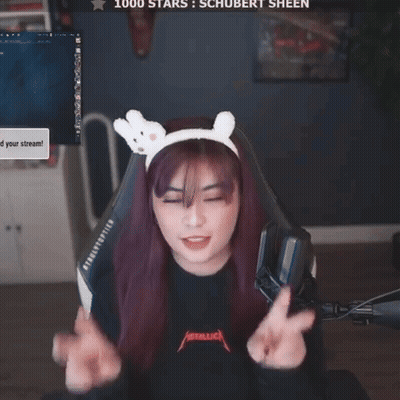 A Woman Wearing A Headband With Bunny Ears Is Giving A Peace Sign In Front Of A Screen That Says 1000 Stars GIF