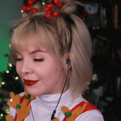 A Woman Wearing A Headband With Red Berries On It Is Smiling . GIF