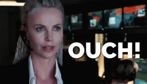 A Woman Wearing A Headset Says Ouch In Front Of A Monitor GIF