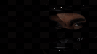 A Woman Wearing A Helmet Is Reflected In A Car Mirror GIF