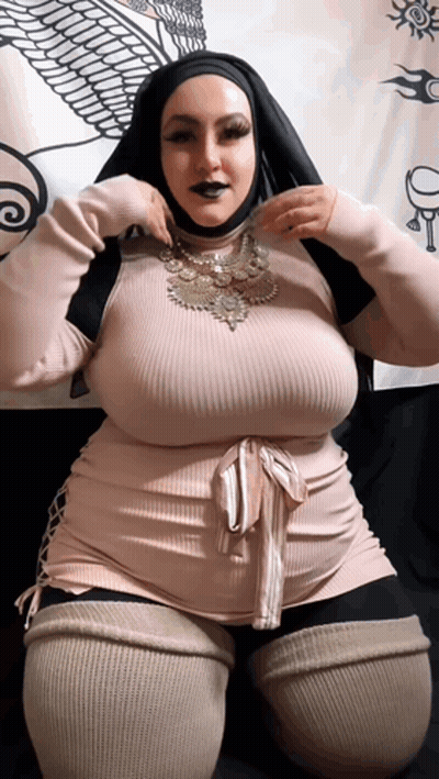 A Woman Wearing A Hijab Is Kneeling Down With Her Hands On Her Hips GIF