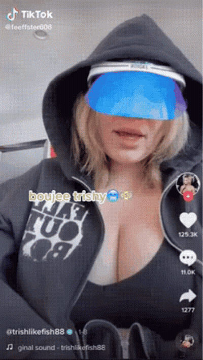 A Woman Wearing A Hoodie And A Blue Visor Is A Tiktok Video . GIF