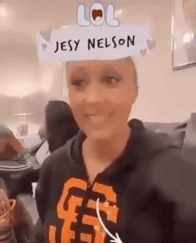 A Woman Wearing A Hoodie With The Name Jesy Nelson On Her Head . GIF