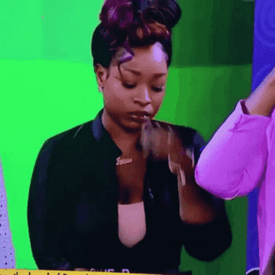 A Woman Wearing A Jacket With A Name Tag That Says Janelle GIF