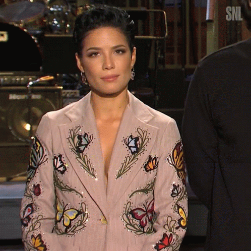 A Woman Wearing A Jacket With Butterflies And Flowers On It GIF