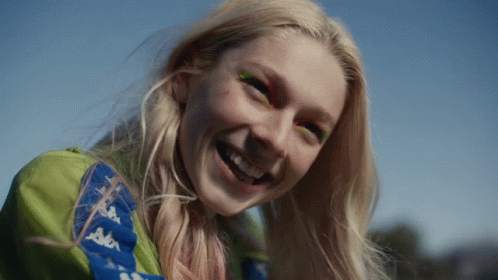 A Woman Wearing A Kappa Jacket Smiles With Her Eyes Closed GIF